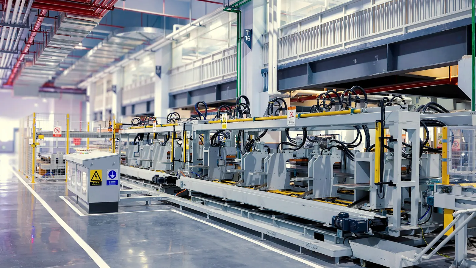 A wide view down a bright production hall with long machine lines