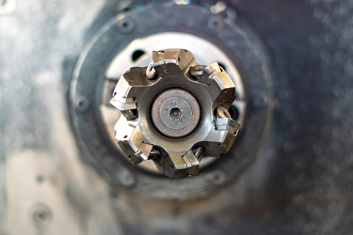 An indexable face mill seen end-on, with its carbide inserts and clamping screws