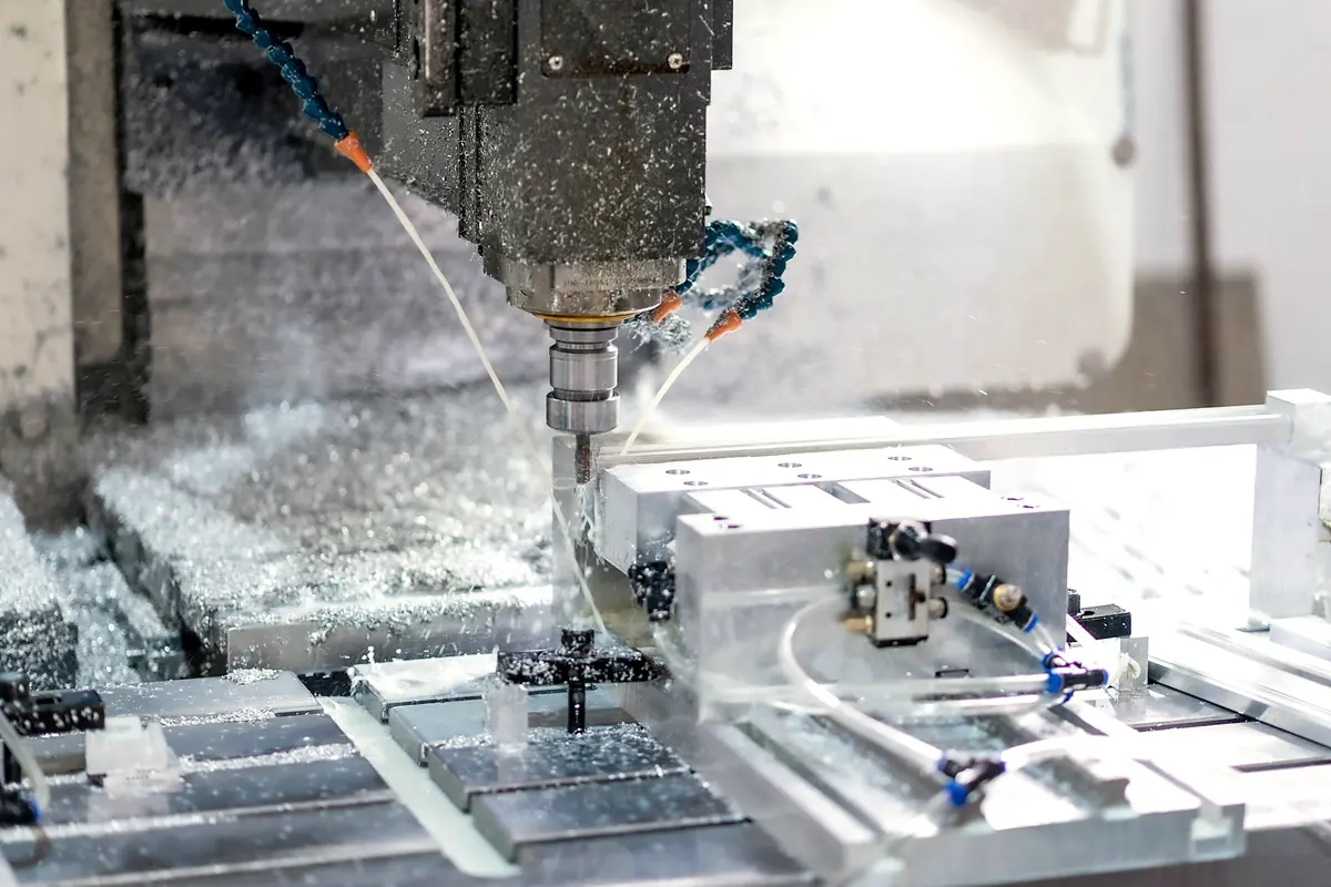 A milling spindle cutting an aluminum part under a jet of coolant