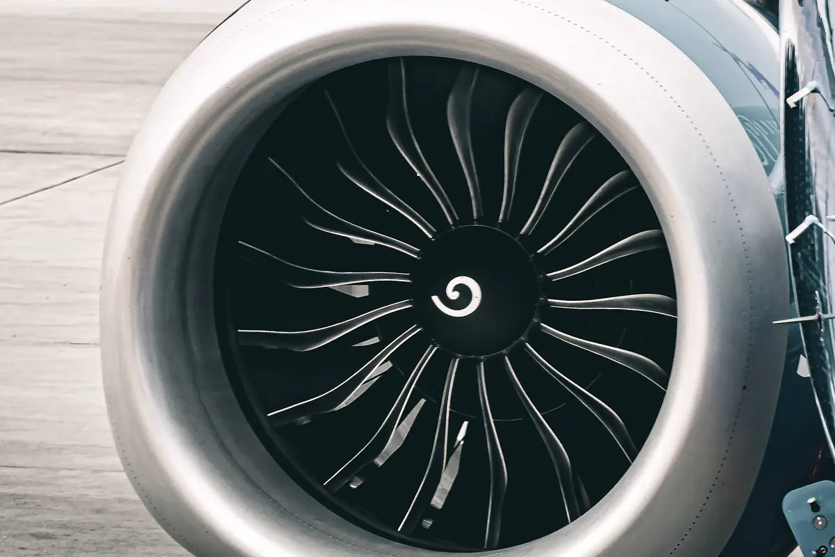 A turbofan engine nacelle and its polished intake lip under an aircraft wing
