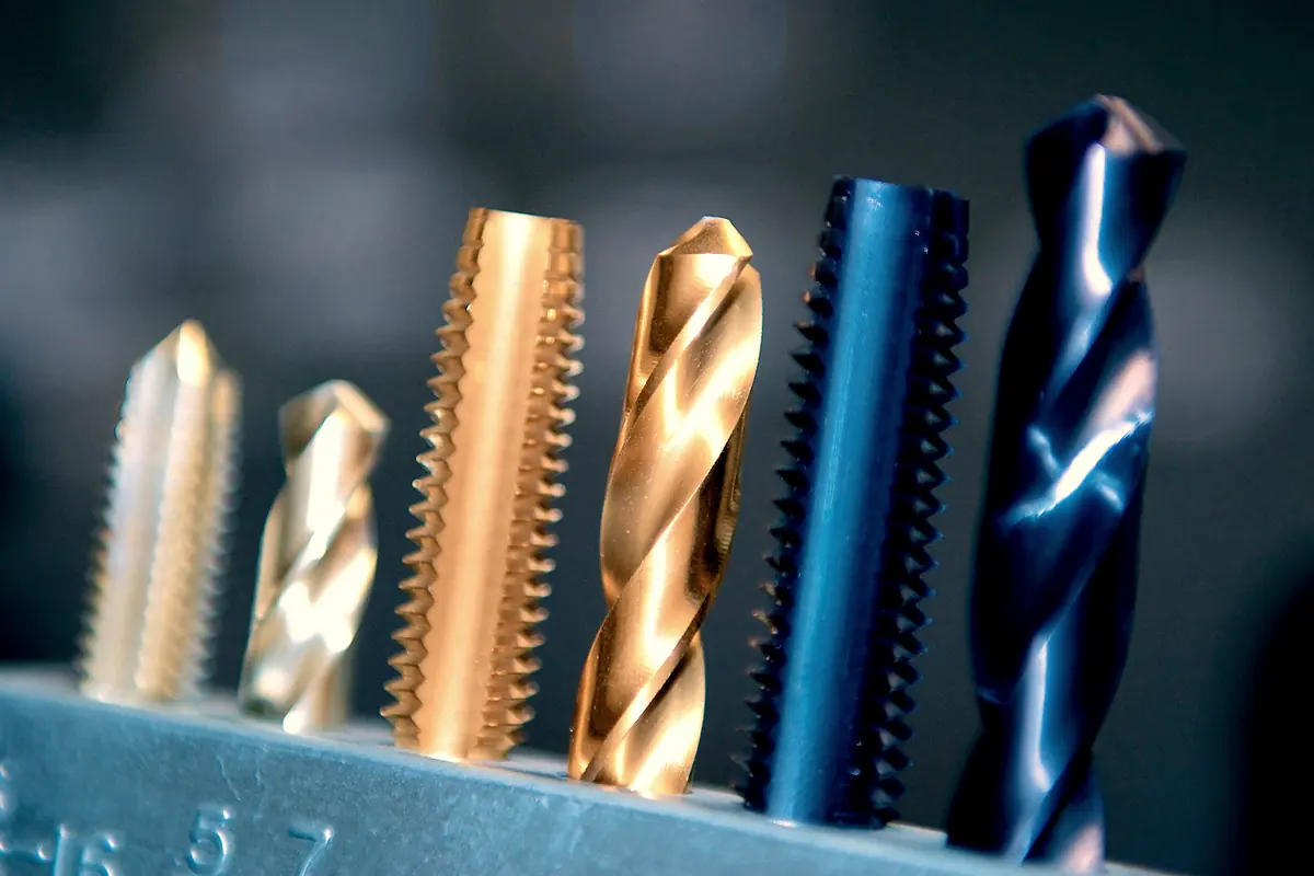 Taps and twist drills in a steel index rack, several gold titanium nitride coated