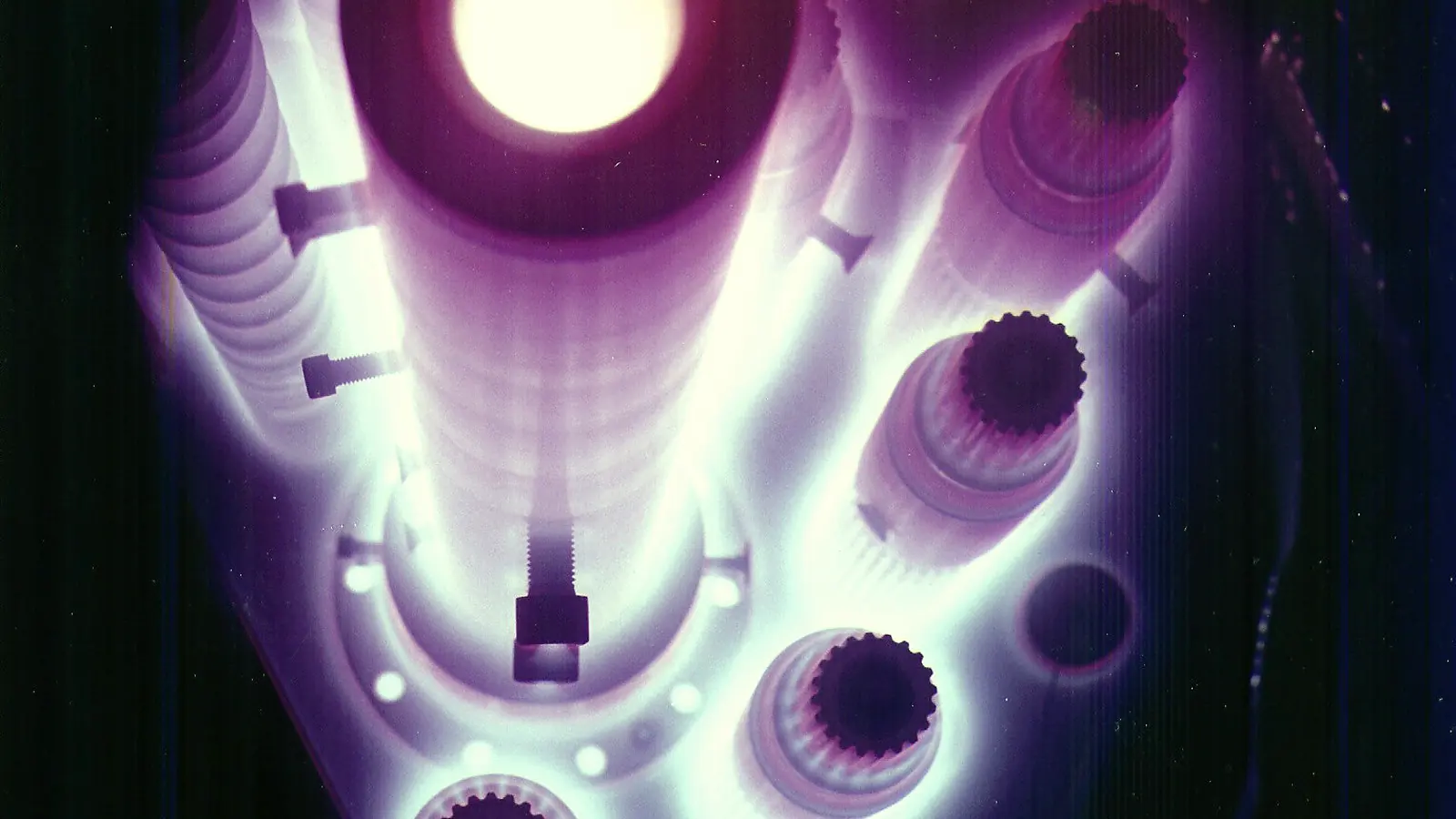 Violet glow discharge around steel workpieces inside a vacuum plasma chamber